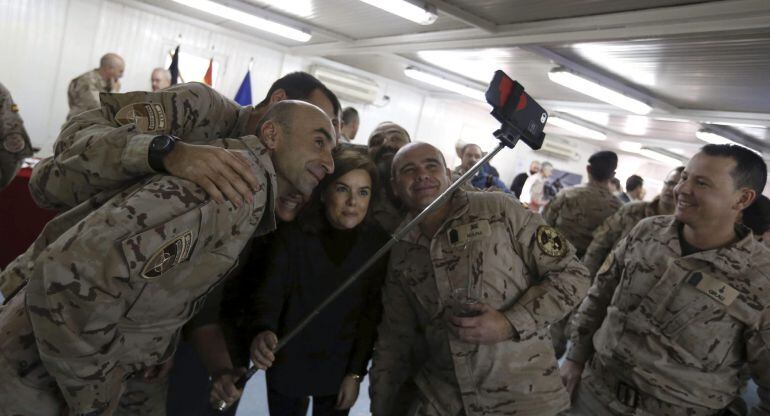 GRA021 HERAT (Afganistan), 15/12/2014.- La vicepresidenta del Gobierno, Soraya Sáenz de Santamaría, se hace un autoretrato con varios militares de la Base de Herat donde ha llegado hoy para visitar a las tropas españolas desplegadas en este país, en lo que constituye su primer viaje a una misión en el exterior desde que ocupa el cargo.Este viaje, que se ha mantenido en secreto hasta ahora por motivos de seguridad, es el primero que realiza a una misión militar en el exterior como vicepresidenta del Gobierno.España tiene actualmente desplegados 464 militares en Afganistán, la mayoría de ellos destinados en la base de Herat, encargados de gestionar el aeropuerto y el hospital Role 2, así como de la protección de la base. EFE/ Javier Lizón