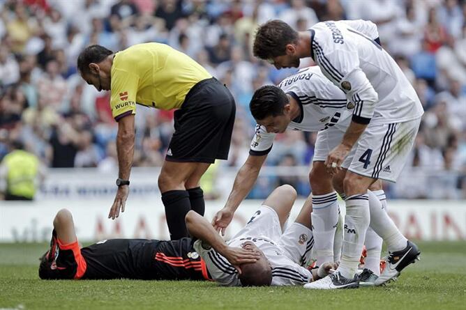 El defensa portugués del Real Madrid Pepe se duele en el suelo tras chocar con el portero Iker Casillas en la jugada del gol de Jonas para el Valencia CF