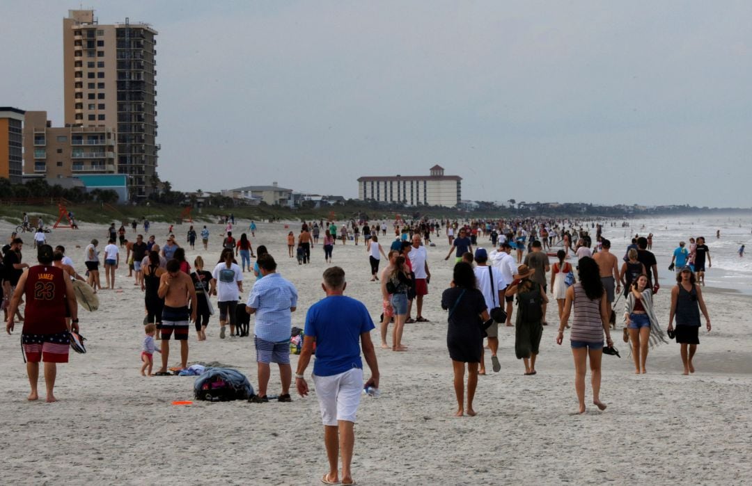 Cientos de personas caminan por la playa de Jacksonville (Florida) sin mantener precauciones de distancia tras poner fin al confinamiento. 