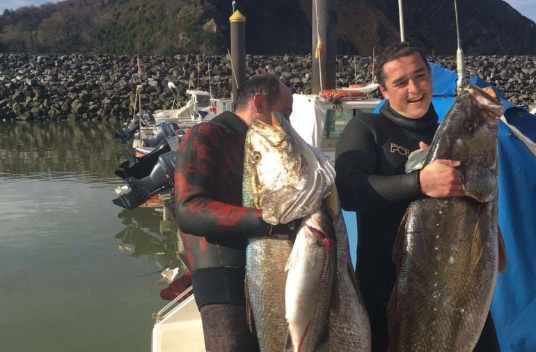 Zigor y Ander posando orgullosos con sus trofeos en el puerto de Orio