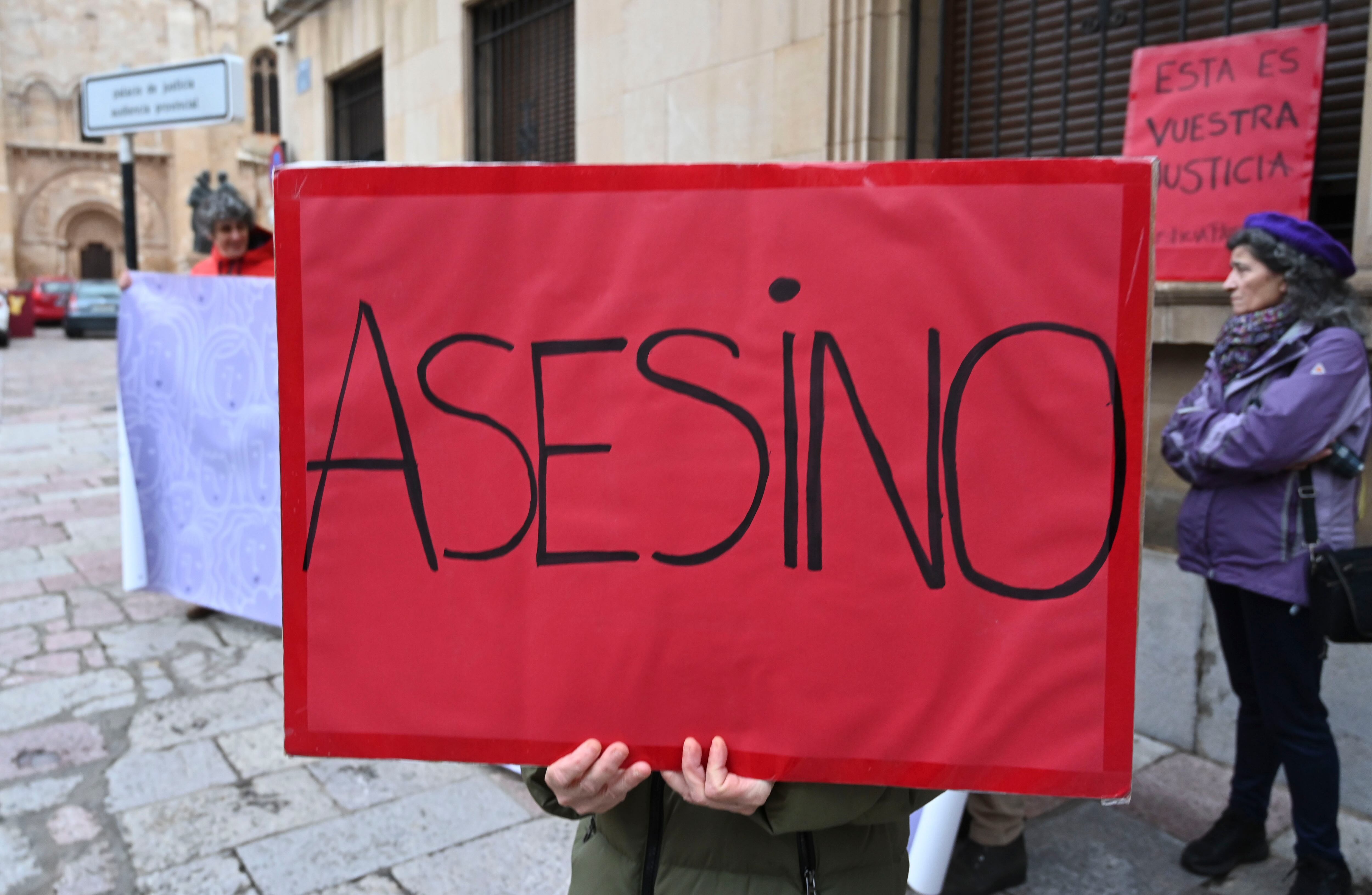 LEÓN, 11/12/2023.- Una persona sostiene un cartel en el que se lee asesino a la llegada de Raquel Díaz , exmujer de Pedro Muñoz, al juicio por malos tratos este lunes en la Audiencia Provincial de León. La Audiencia de León abre el juicio contra el exconcejal del Ayuntamiento de Ponferrada (León) Pedro Muñoz, acusado de tirar a la que entonces era su mujer por el balcón de la vivienda que compartían y causarle lesiones que la han dejado en silla de ruedas, y para el que el Ministerio Fiscal reclama una pena de 18 años y 9 meses de prisión por cinco delitos. EFE/J. Casares