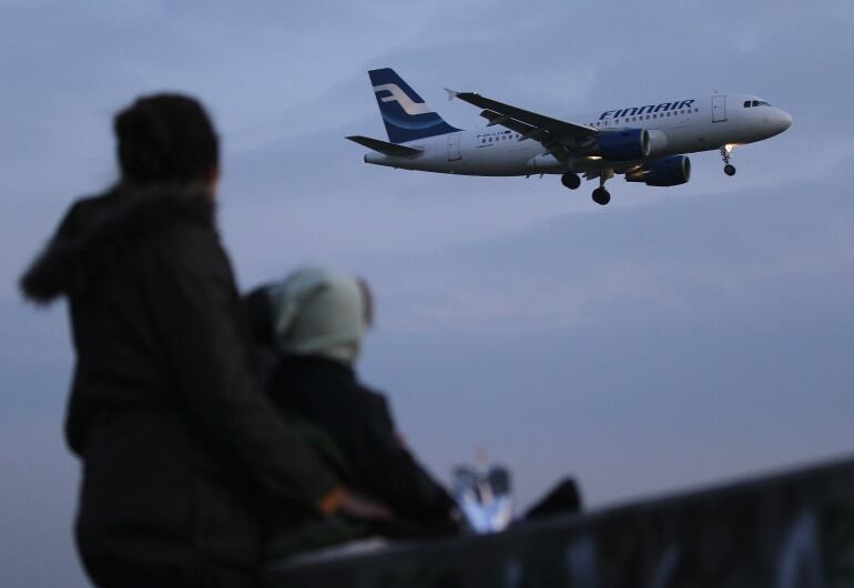 Dos personas observan un avión de la compañía Finnair