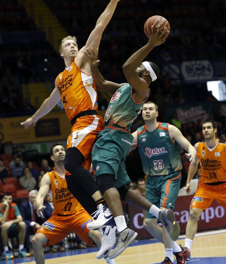 El alero estadounidense del CB Sevilla, LaDontae Henton (c), lanza a canasta ante Justin Hamilton (i), del Valencia Basket, en una jugada del partido de Liga Endesa que disputan hoy en el Palacio de Los Deportes de Sevilla. EFE-Julio Muñoz