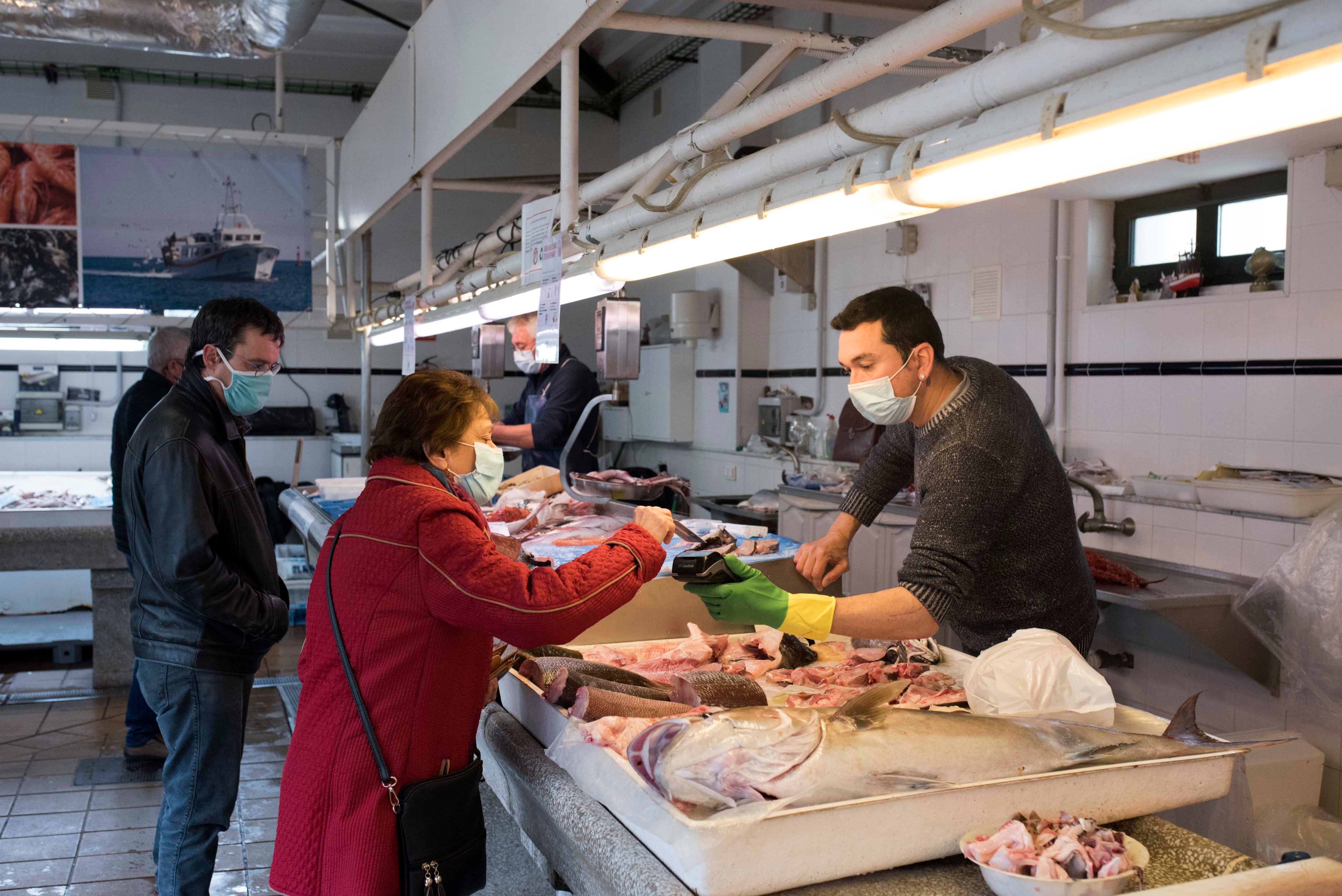 Varias personas compran en el mercado de Es Claustre de Mahón, Menorca