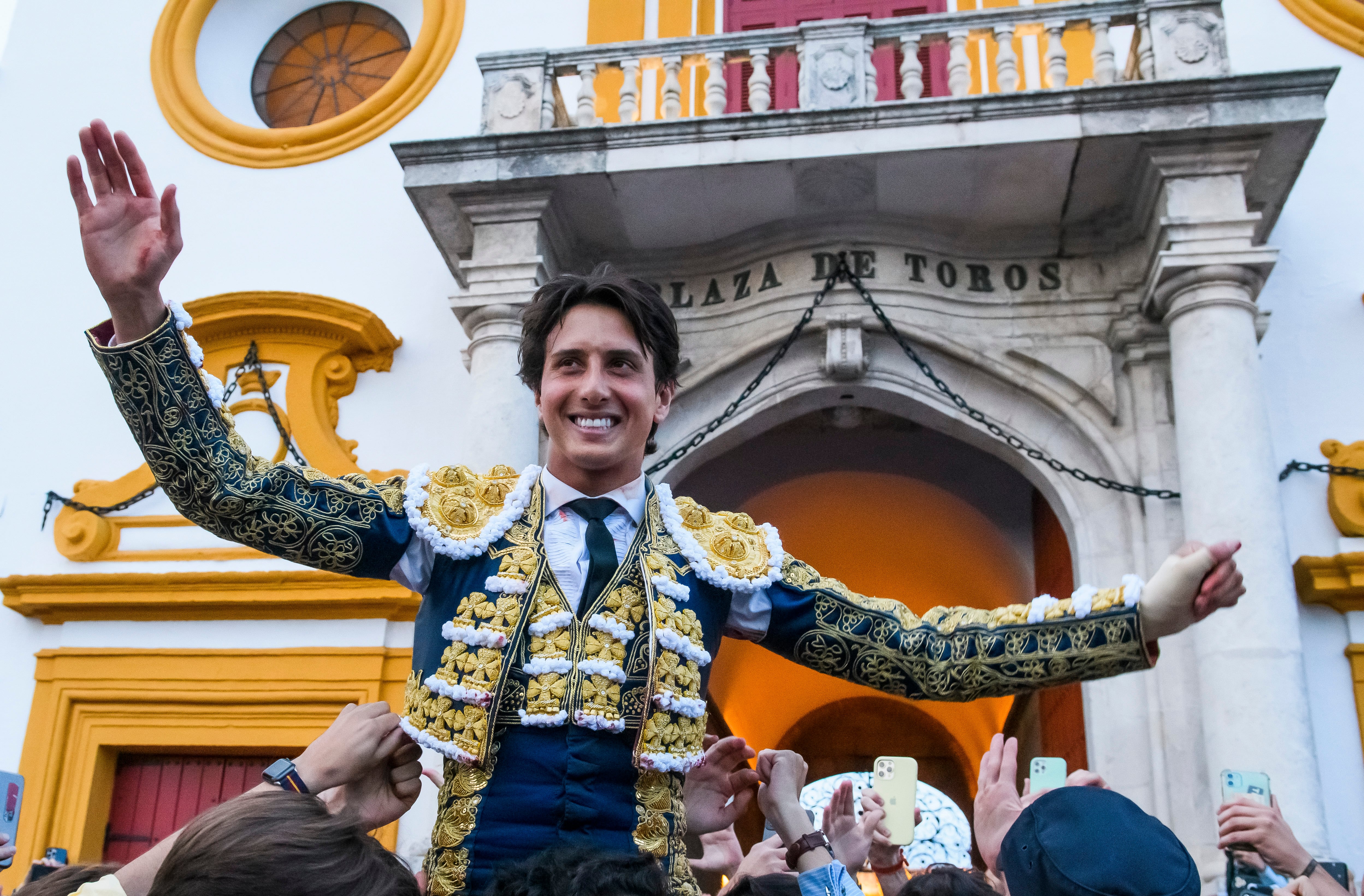 SEVILLA, 21/04/2023.- El diestro peruano Andrés Roca Rey sale a hombros por la Puerta del Príncipe tras cortar una oreja a su primer toro y dos al segundo, este viernes en la Real Maestranza de Sevilla. EFE/ Raúl Caro
