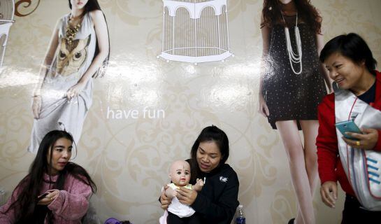 A devotee dresses up her &quot;child angel&quot; doll inside a department store in Bangkok, Thailand, January 26, 2016. A craze for lifelike dolls thought to bring good luck is sweeping Thailand, reflecting widespread anxiety as the economy struggles and political 