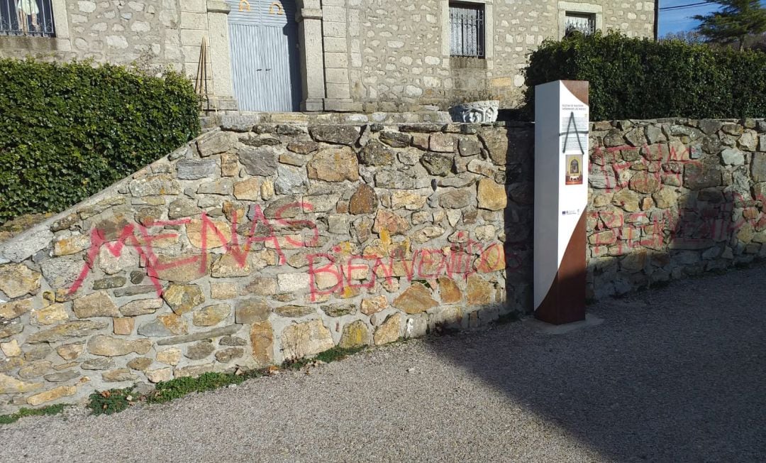 Murete de la Iglesia de Somosierra con pintadas a favor de la acogida de &#039;menas&#039;