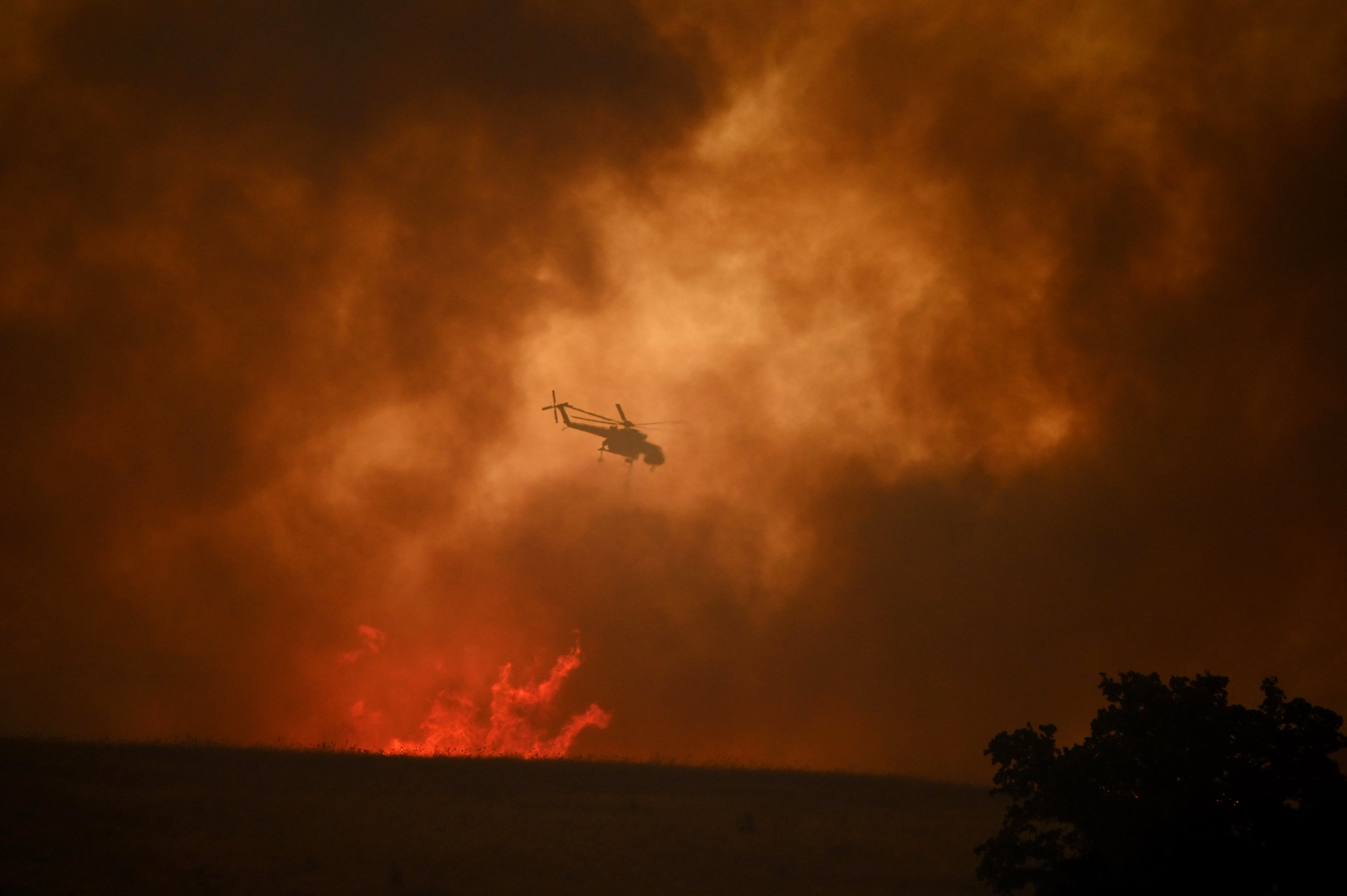 Un helicóptero intenta apaciguar las llamas en Avantas, cerca de  Alexandroupolis, al norte de Grecia