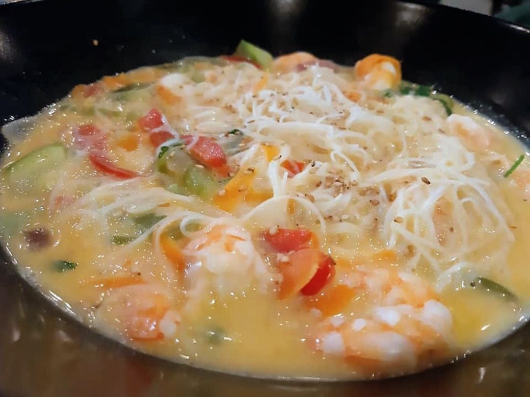 Wok de fideos de arroz con langostinos, verduras y leche de coo