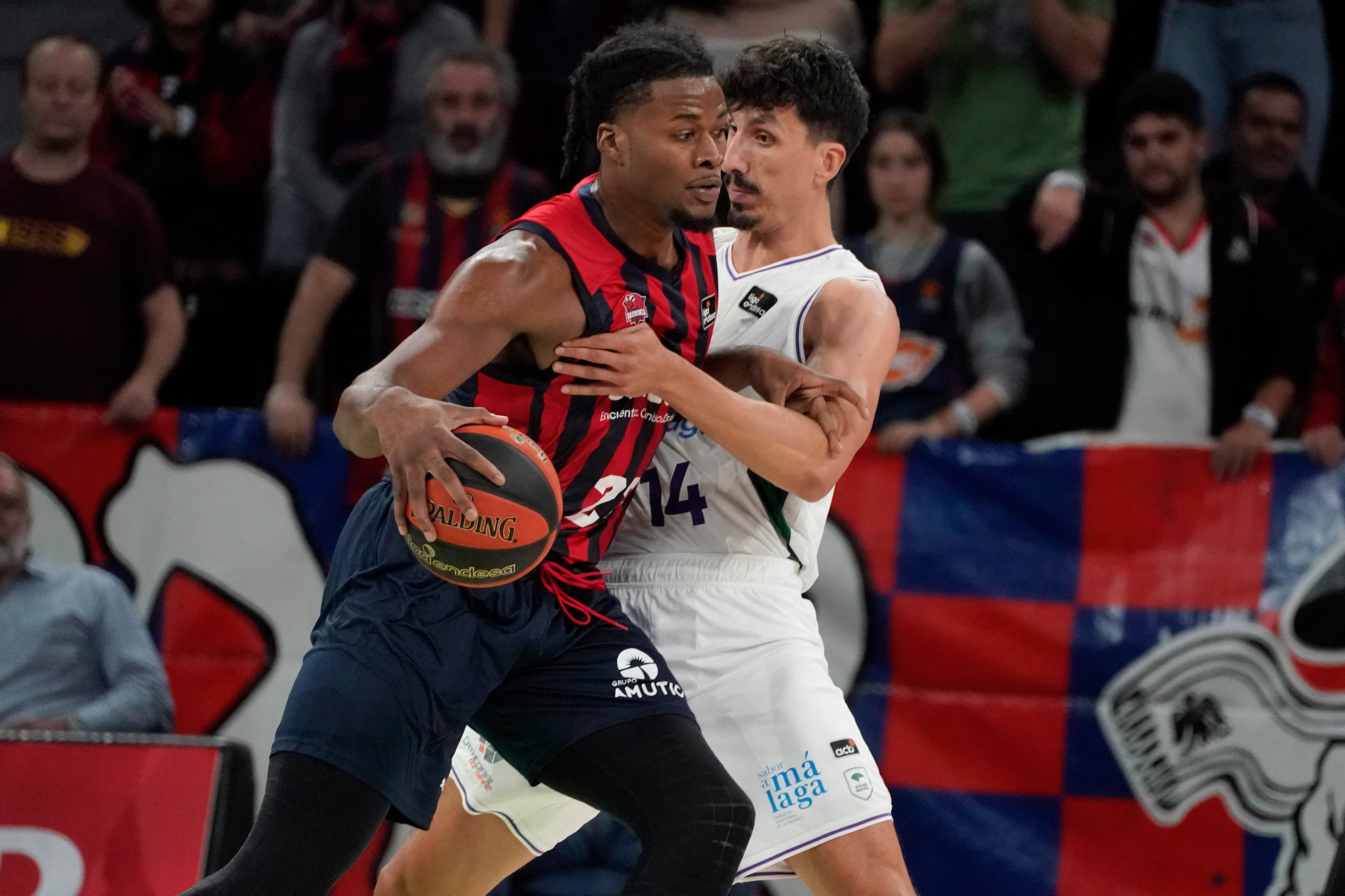 Steven Enoch (i) lucha con el bosnio Nihad Dedovic, de Unicaja, durante el partido de la primera jornada de la Liga Endesa. EFE/ L. Rico