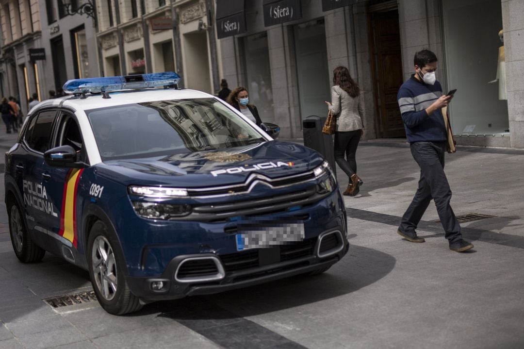 Un coche de la Policía Nacional patrulla por las inmediaciones de la Puerta del Sol, en Madrid 