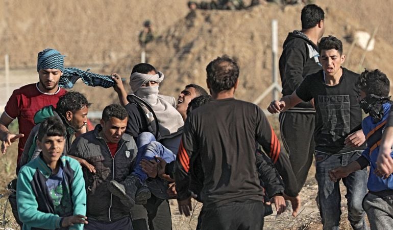 Los manifestantes palestinos llevan a un joven herido durante los enfrentamientos con las tropas israelíes a lo largo de la frontera entre Israel y la Franja de Gaza.