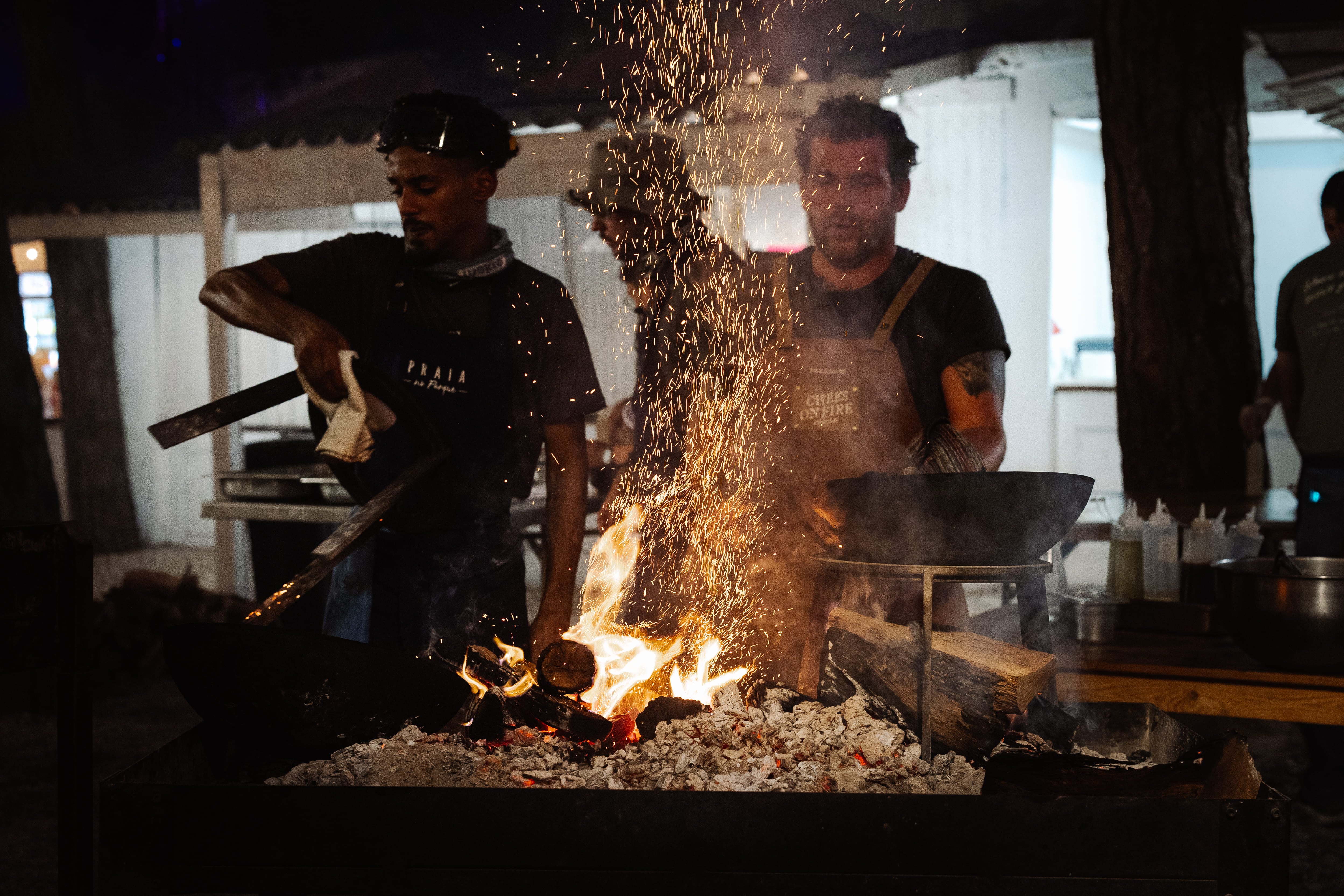 Cocineros en acción, frente a las brasas.