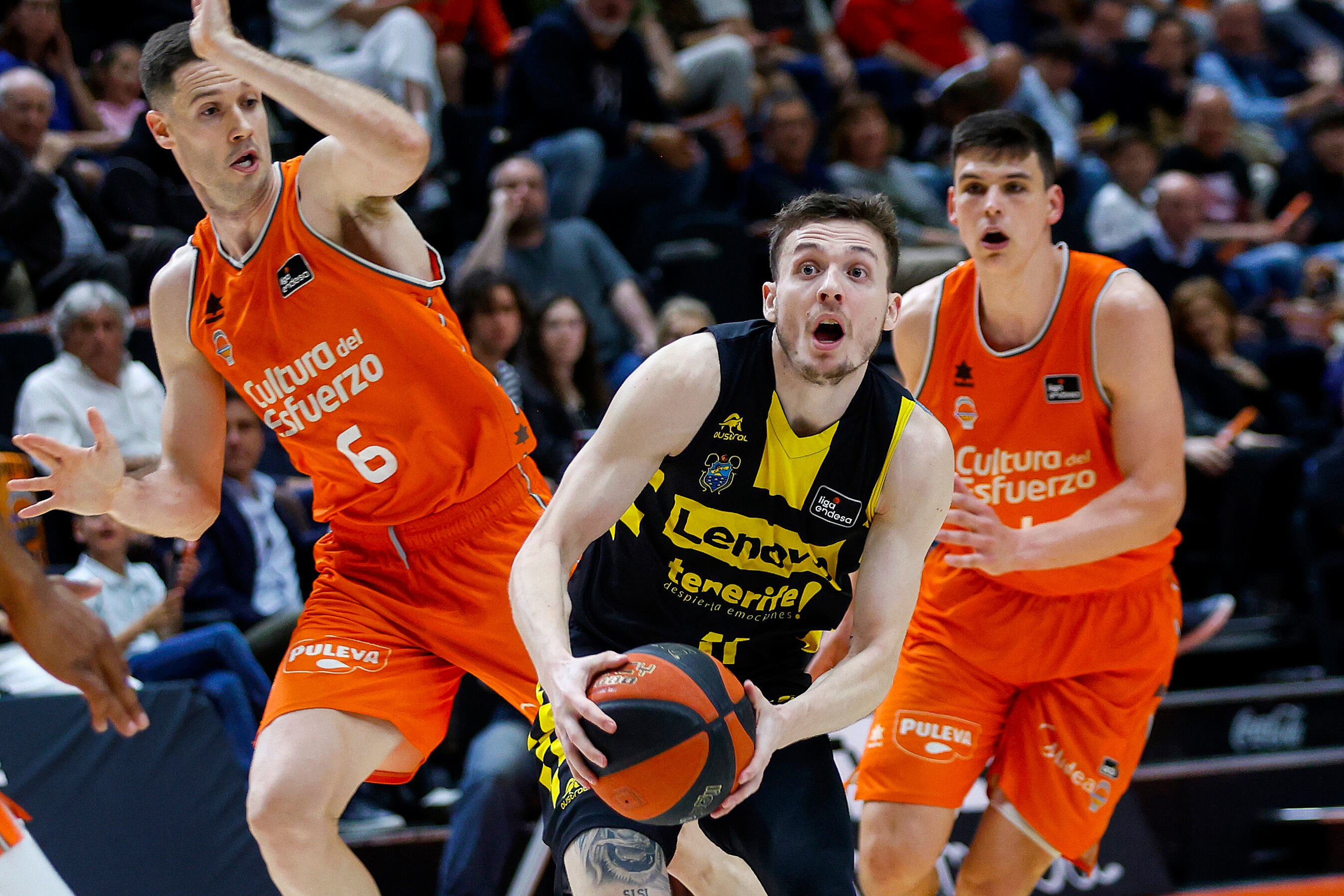 VALENCIA, 21/04/2024.- El escolta de Lenovo Tenerife Kyle Guy (c) controla el balón delante de Xavi López-Arostegui (i), del Valencia Basket, durante el partido de Liga Endesa disputado este domingo en el pabellón de la Fuente de San Luis de Valencia. EFE/ Miguel Ángel Polo