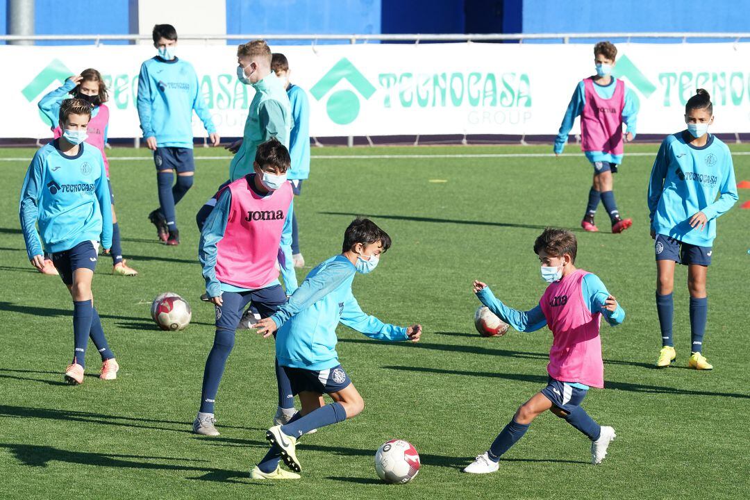 Varios jugadores de la cantera azulona se entrenan con mascarillas.