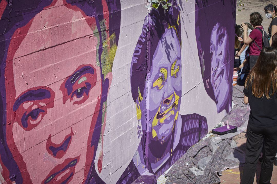 Varias personas pintan de nuevo el mural feminista de Unlogic Crew junto a la estación de Getafe Central