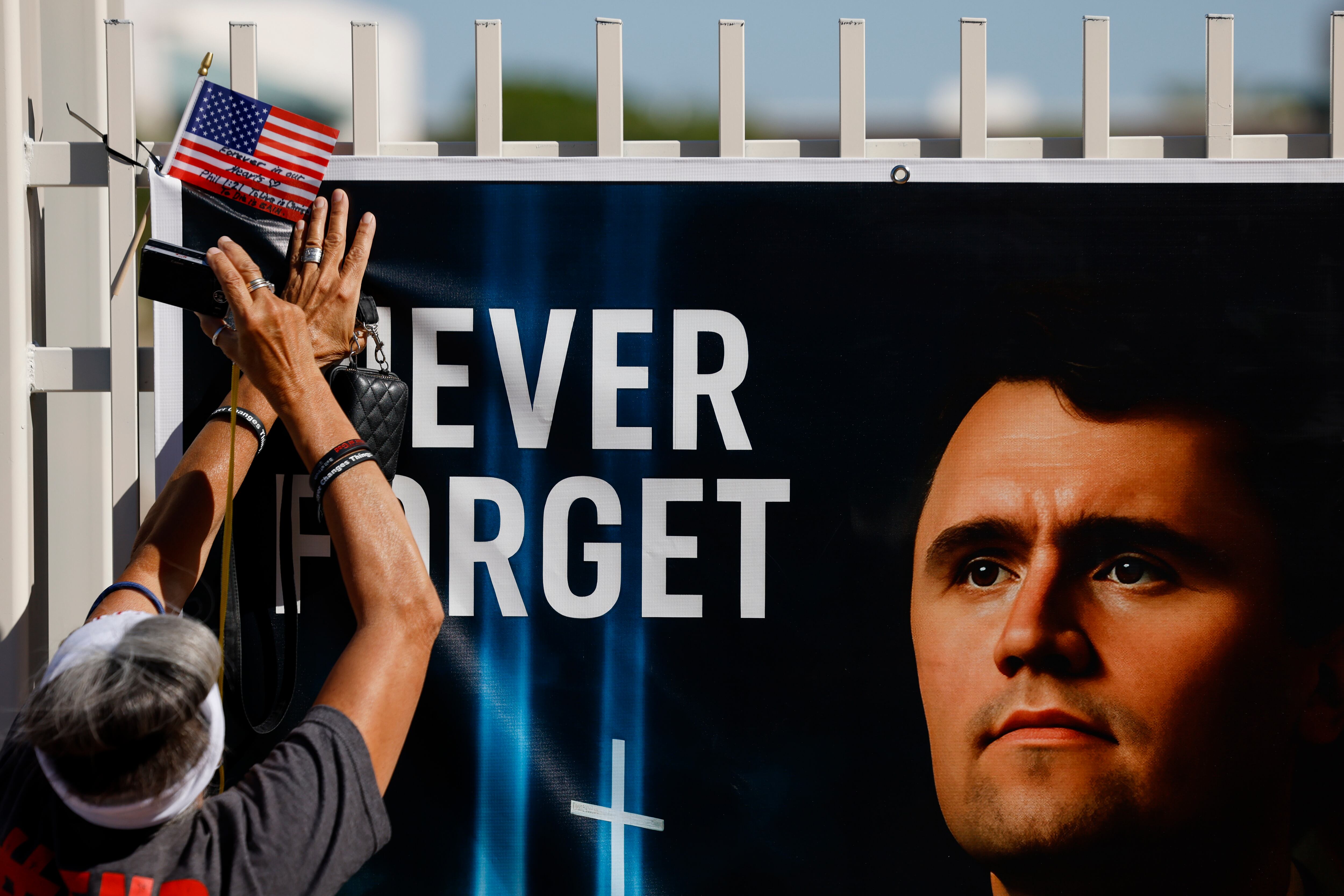 Una persona coloca una pancarta de Charlie Kirk en su homenaje el 20 de septiembre, en Fénix, Arizona (EEUU).