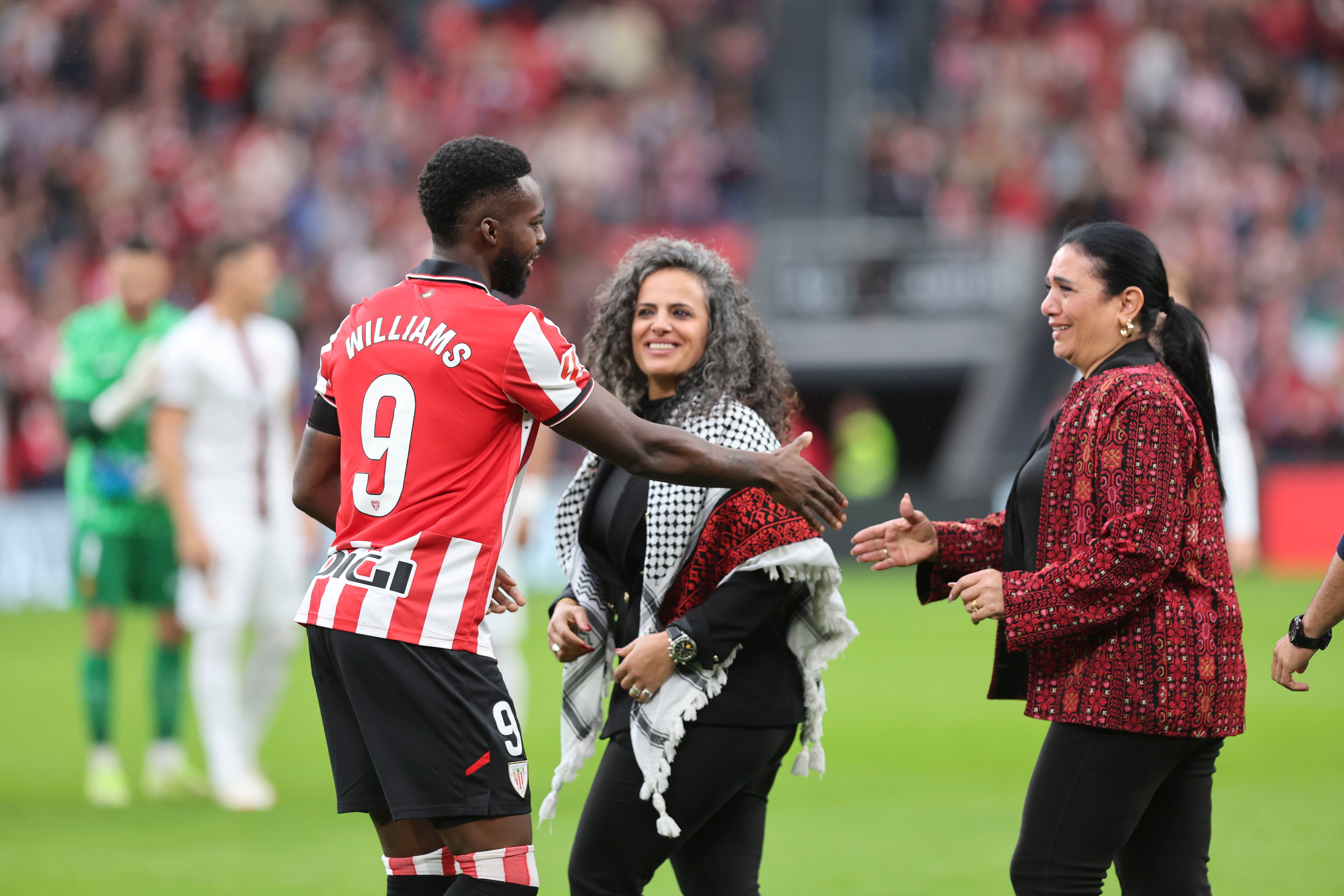 BILBAO, 04/10/2025.-El delantero del Athletic Club Iñaki Williams, saluda a dos mujeres palestinas, durante el partido de la jornada 8 de LaLiga EA Sports entre el Athletic Club y el Mallorca, este sábado en el estadio de San Mamés en Bilbao.-EFE/ Luis Tejido