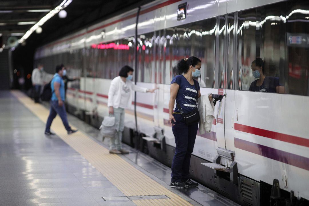 Pasajeros con mascarilla en la estación de cercanías de Nuevos Ministerios de Madrid.