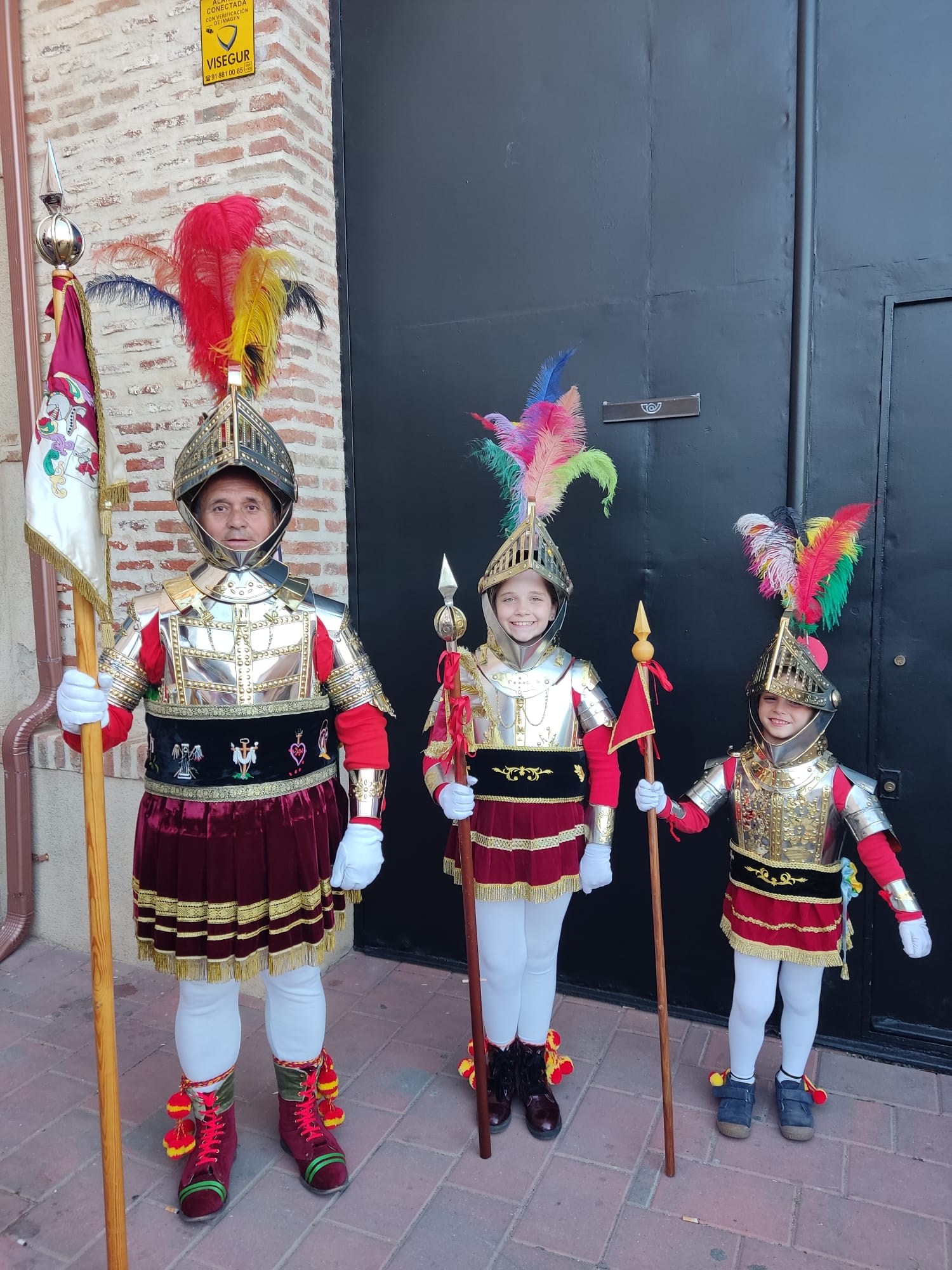 Abuelo con sus nietos, ataviados con la armadura de los Armaos, que acompañarán en la procesión del Santo Entierro