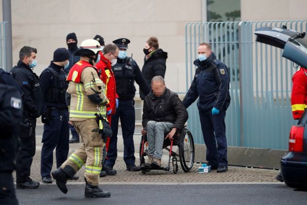 Los bomberos atienden al hombre que se estrelló con su automóvil contra la puerta principal de la cancillería en Berlín