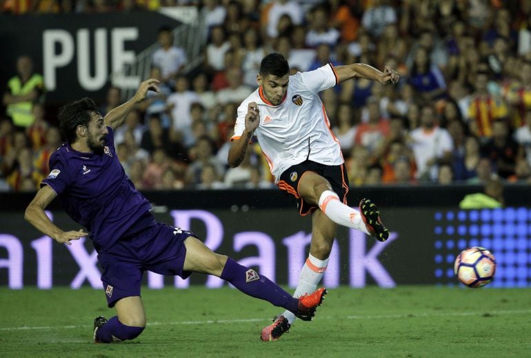 GRA252. VALENCIA, El delantero del Valencia CF, Rafa Mir (d), chuta para marcar el segundo gol de su equipo junto al defensa de la ACF Fiorentina, Davide Astori, durante el partido amistoso que juegan ambos equipos tras la presentación de la primera plant