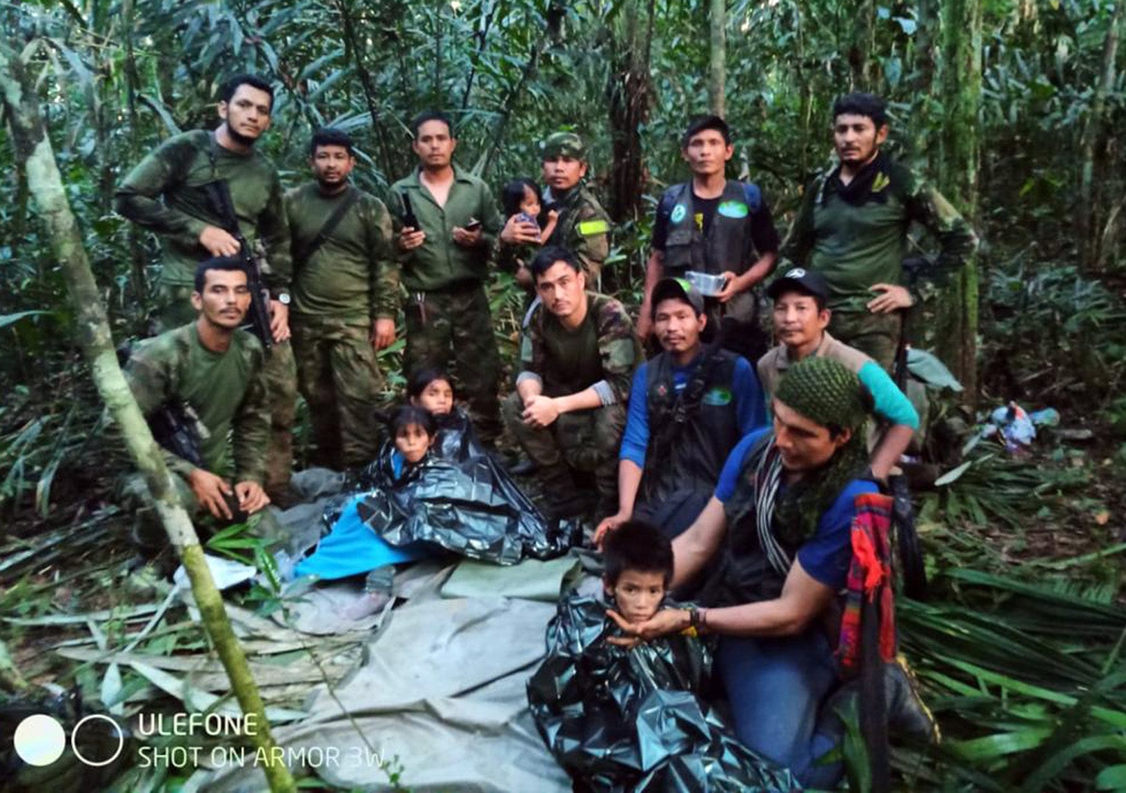 Fotografía cedida hoy por las Fuerzas Militares de Colombia que muestra a soldados e indígenas junto a los niños rescatados tras 40 días en la selva, en Guaviare (Colombia).