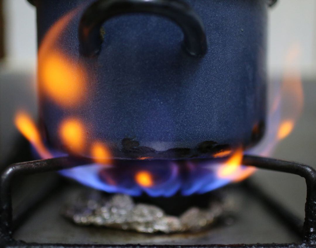 Una olla es calentada sobre el fuego de una cocina de gas