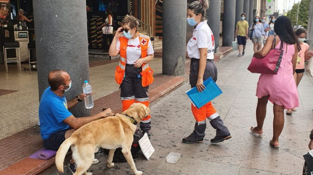 Imagen de archivo de dos voluntarias de Cruz Roja informando a una persona sin techo del dispositivo por altas temperaturas que se activó en Alicante