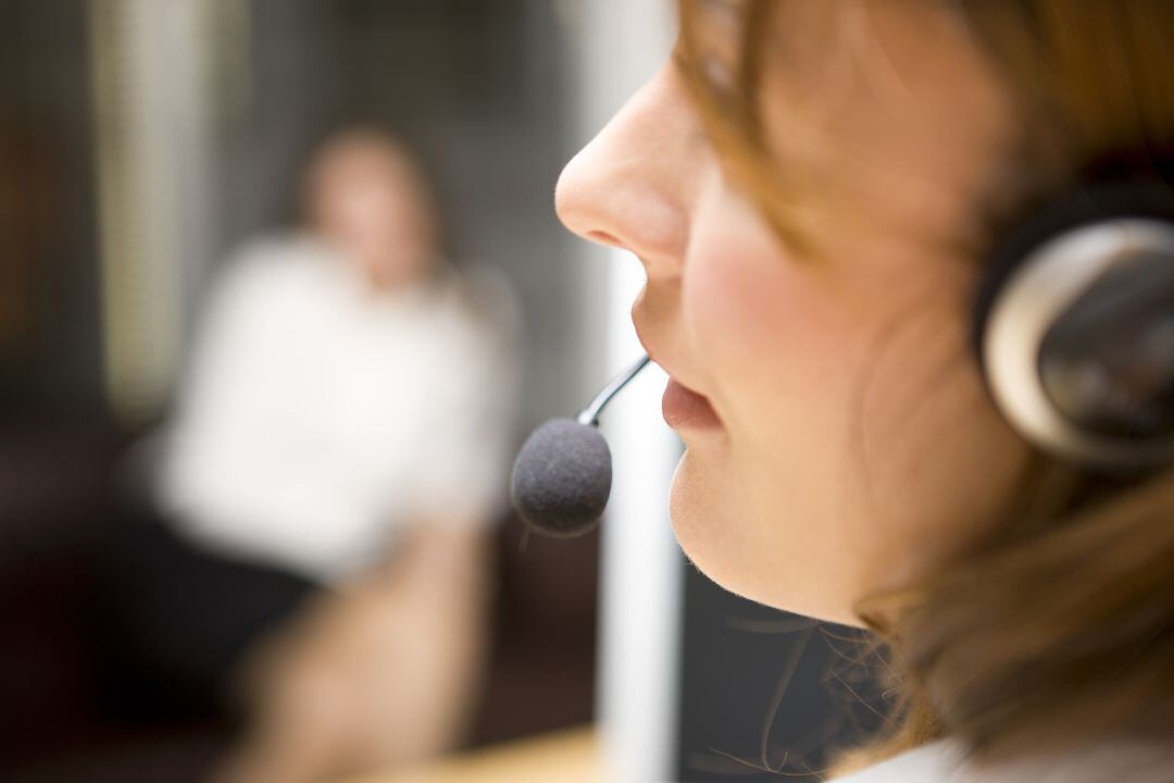 Una mujer atiende por teléfono a un usuario.