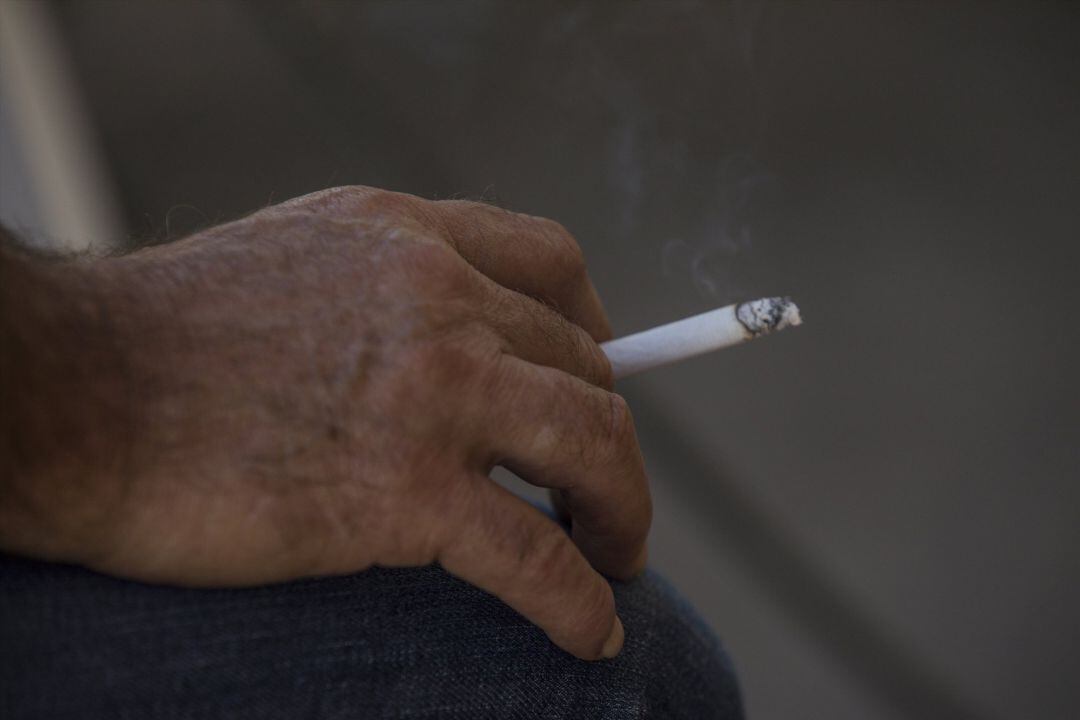 Una persona fuma en la terraza de un bar.