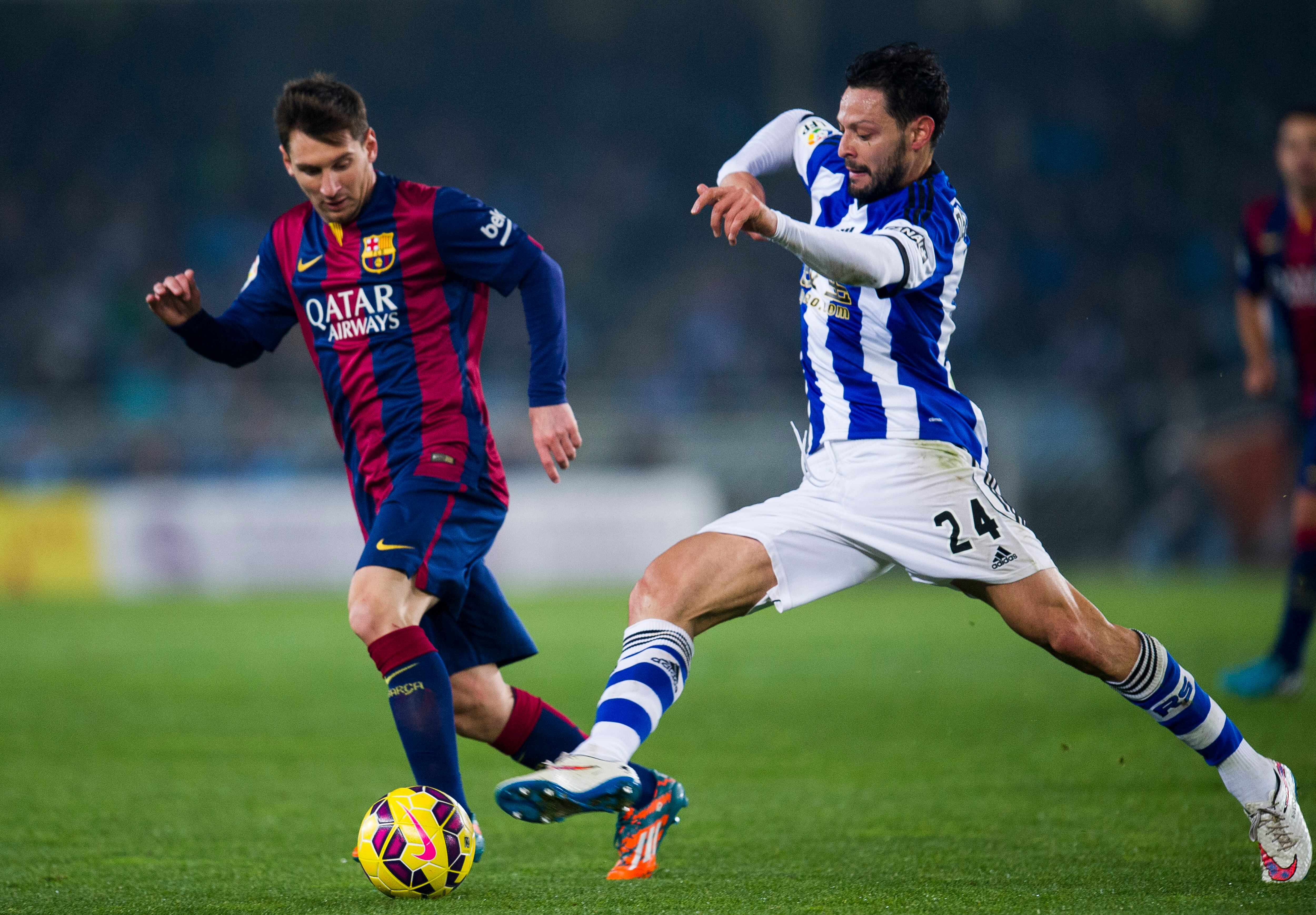 SAN SEBASTIAN, SPAIN - JANUARY 04:  Lionel Messi of FC Barcelona duels for the ball with Alberto De La Bella of Real Sociedad during the La Liga match between Real Sociedad and Barcelona at Estadio Anoeta on January 4, 2015 in San Sebastian, Spain.  (Photo by Juan Manuel Serrano Arce/Getty Images)