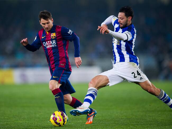 SAN SEBASTIAN, SPAIN - JANUARY 04: Lionel Messi of FC Barcelona duels for the ball with Alberto De La Bella of Real Sociedad during the La Liga match between Real Sociedad and Barcelona at Estadio Anoeta on January 4, 2015 in San Sebastian, Spain. (Photo by Juan Manuel Serrano Arce/Getty Images)