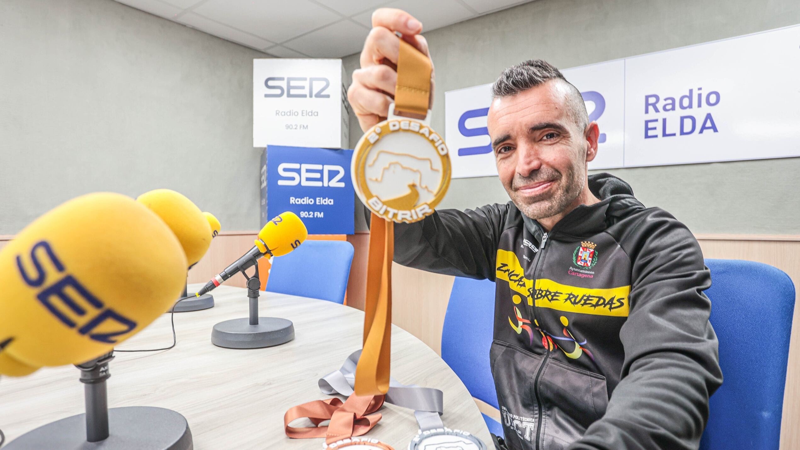 Fran Tenza con las medallas que se entregarán en la carrera