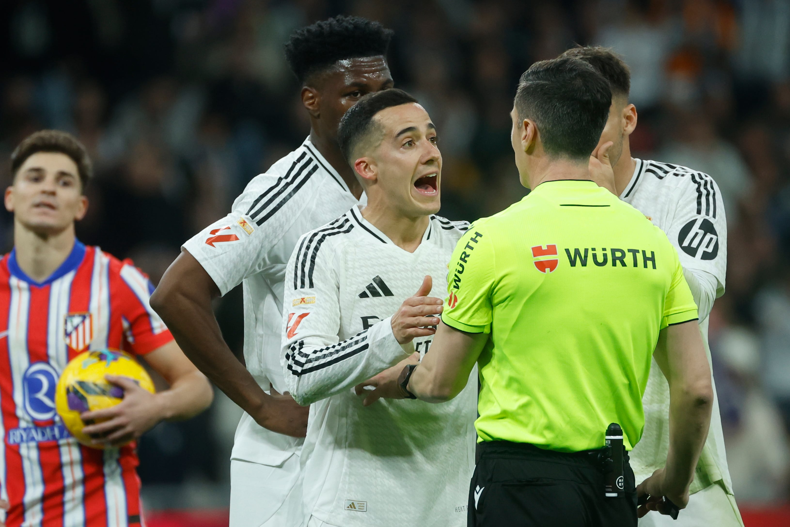 Lucas Vázquez protesta a Soto Grado tras el penalti de Tchouameni