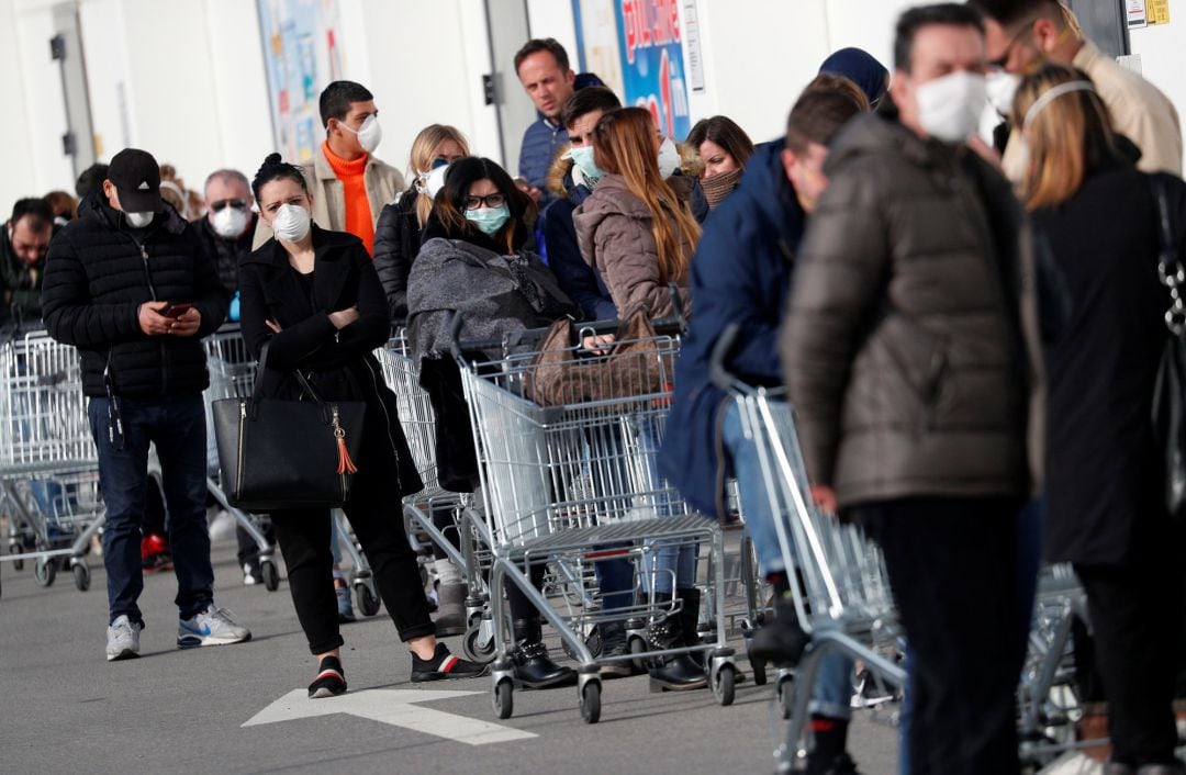 La gente hace cola en un supermercado a las afueras de la ciudad de Casalpusterlengo, que ha sido cerrada por el gobierno italiano por el brote de coronavirus