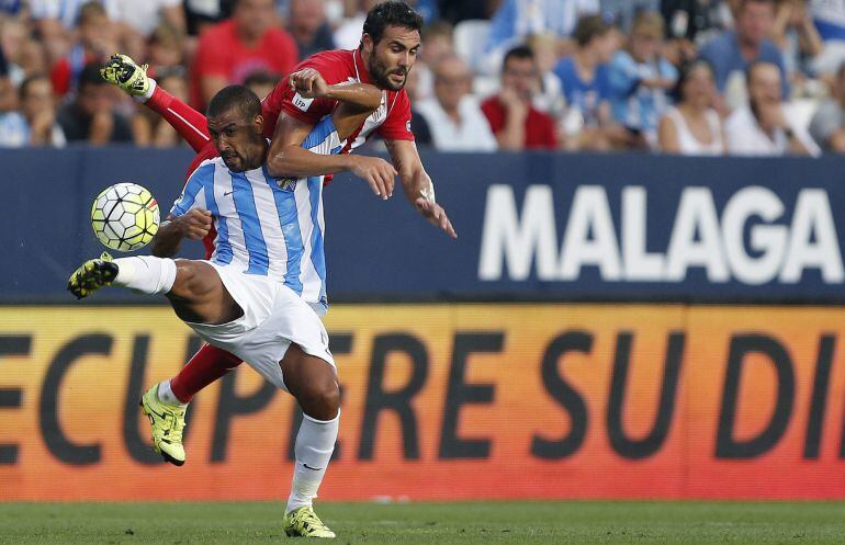 El centrocampista argentino del Málaga CF Fernando Damián Tissone (i) controla el balón ante Vicente Iborra