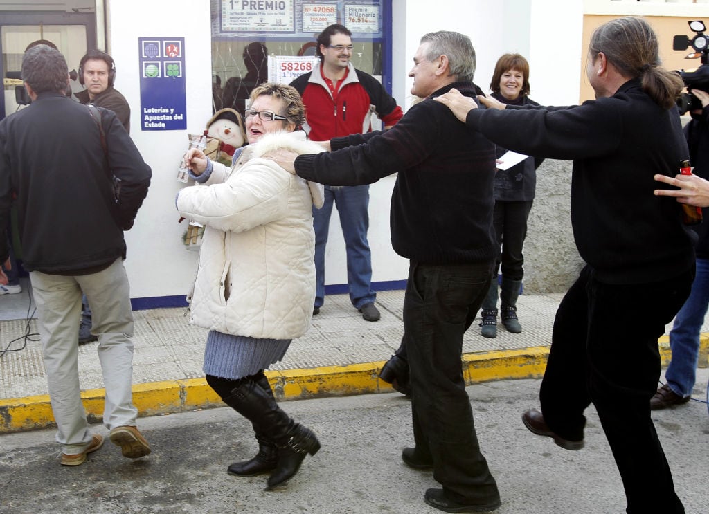 Agraciados con la Lotería de Navidad bailan una conga para celebrarlo.