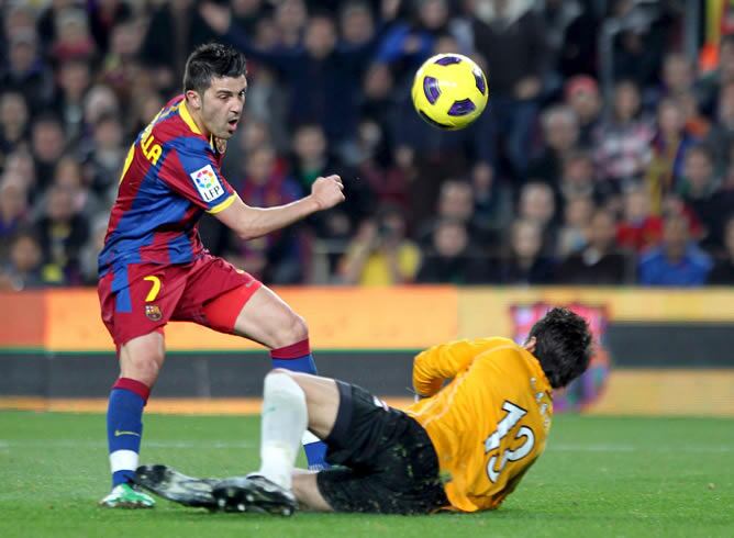 El guardameta del Betis Casto Espinosa detiene el lanzamiento del delantero del F.C. Barcelona David Villa durante el encuentro correspondiente a la ida de los cuartos de final de la Copa del Rey