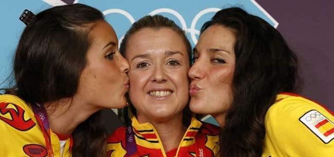 Las nadadoras españolas Ona Carbonel (i) y Andrea Fuentes (d) besaban a su entrenadora, Anna Tarrés, durante los Juegos Olímpicos de Londres