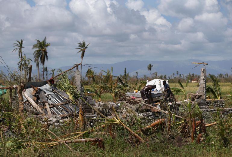 Haiti Un hombre y su hijo colocan ladrillos debajo de una cama, cuya casa fue totalmente destruida durante el paso del huracán Matthew hoy, 7 de octubre de 2016, en Chantal 