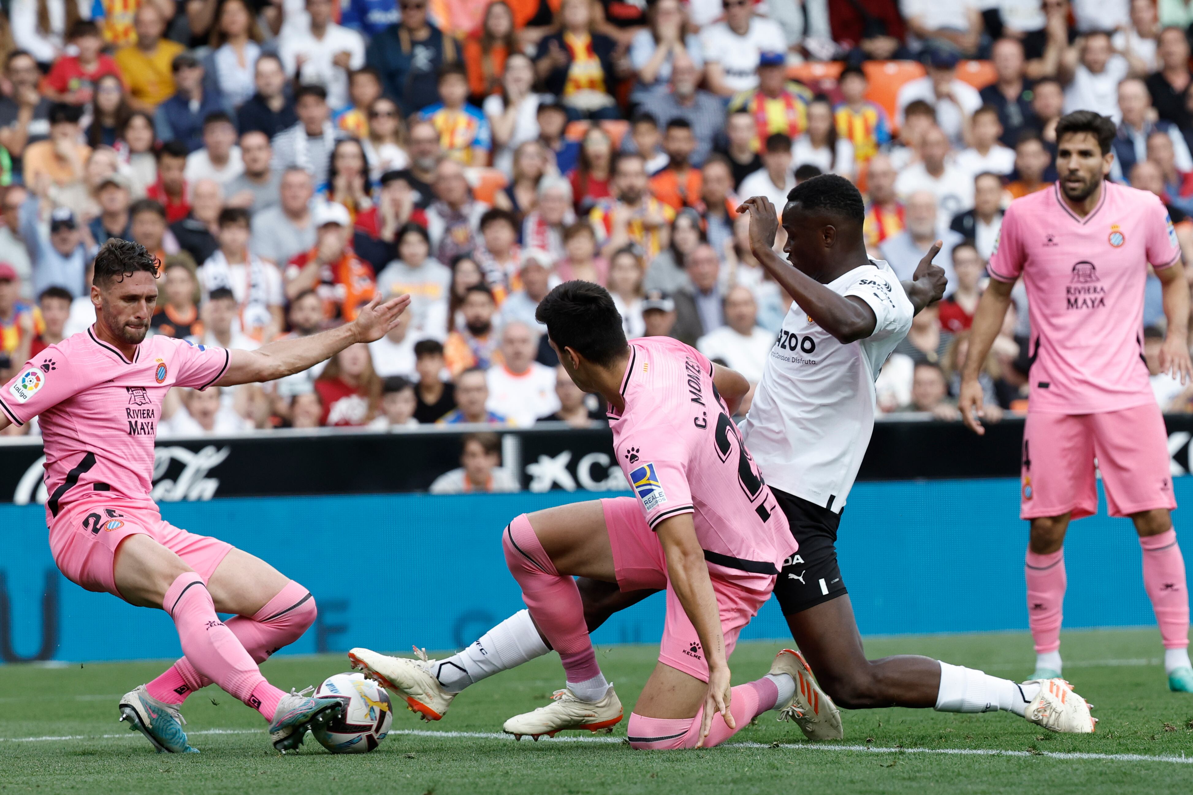 El defensa del Valencia Mouctar Diakhaby (2-d) pelea un balón con César Montes (2-i) y Sergi Gómez (i), ambos del Espanyol, durante el partido de Liga en Primera División que Valencia CF y RCD Espanyol disputan este domingo en el estadio de Mestalla.