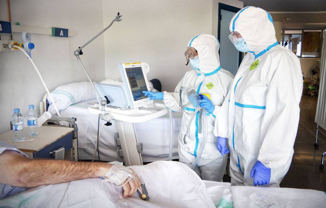 Dos medicos atendiendo a un paciente Covid. 