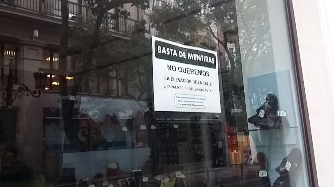 Carteles de oposición a las obras en los comercios