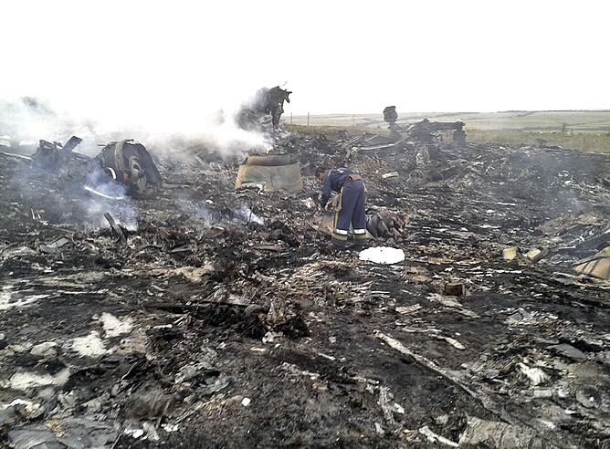 Miembros de Emergencias trabajan junto a los restos del avión malasio.