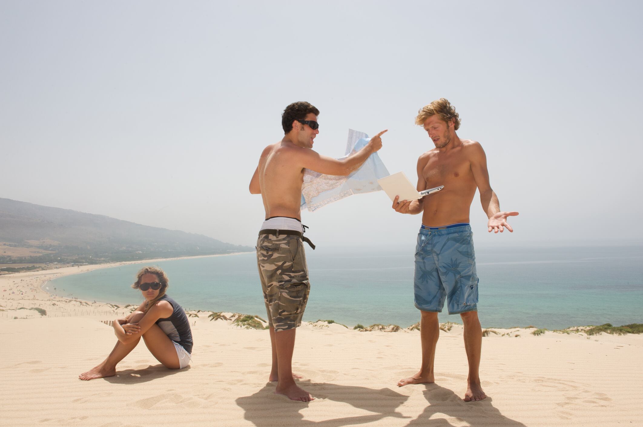 Simulación de dos personas discutiendo en la playa.