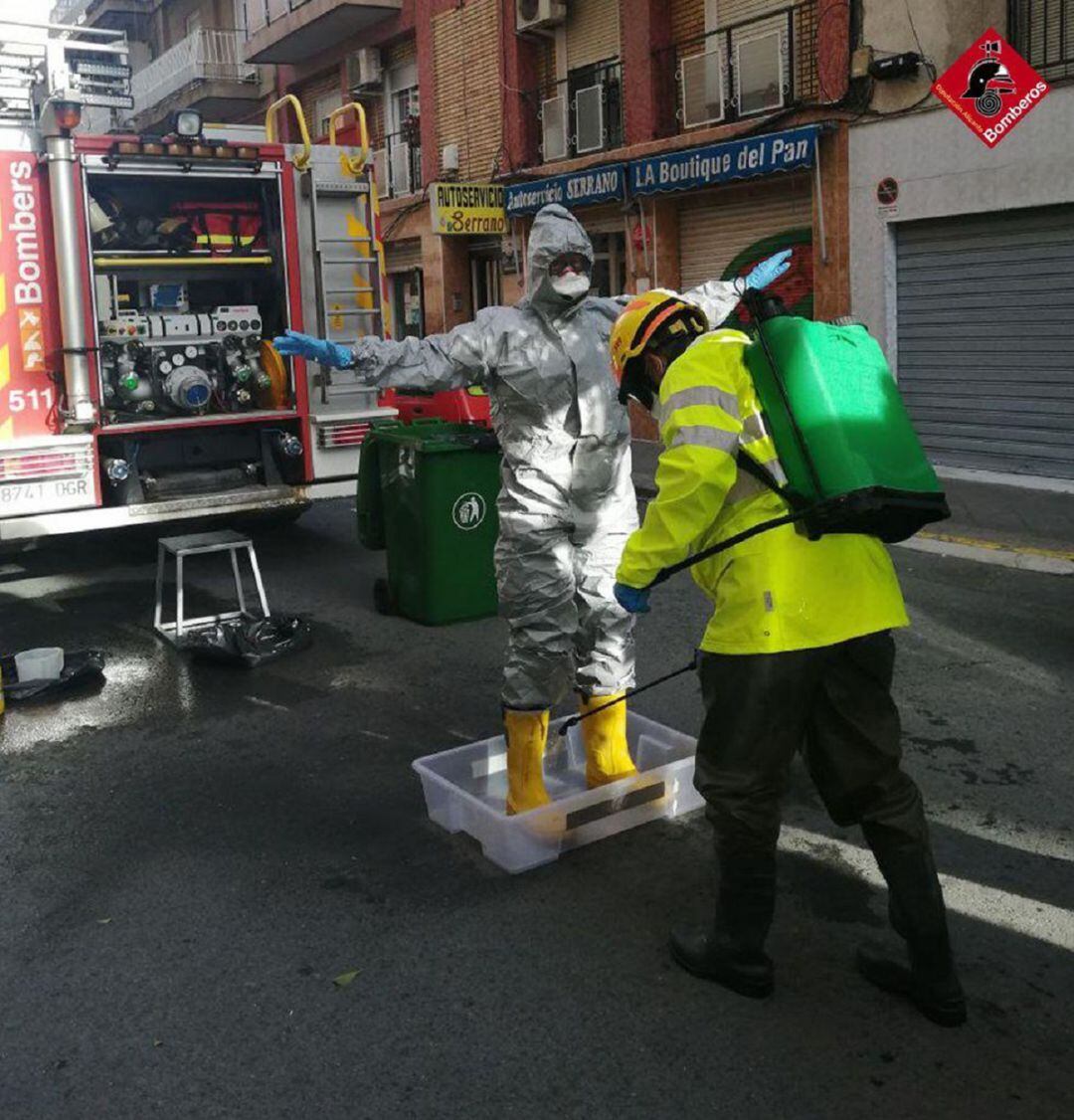 Los Bomberos se deseinfectan al salir de la vivienda donde han encontrado al hombre