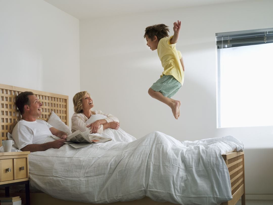 Pareja con niño en la cama.