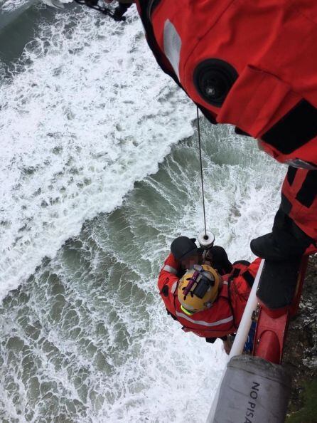 Un técnico de rescate descendió hasta el surfista que fue izado en una operación de grúa.