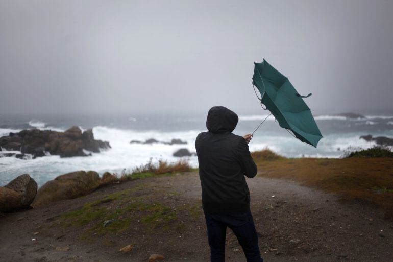  Un hombre ve como el viento le dobla el paraguas en A Coruña. 